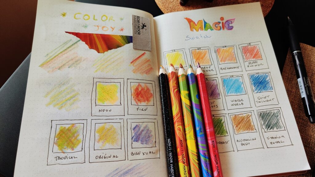 Open journal showing two pages. There’s a bunch of colorful pencils over the right page; it’s titled "Magic Swatch" and it has a color swatch showing the different mixed color combinations. The left page shows another swatch, titled “Color Joy”.